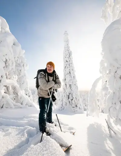 Jarcce luomassa aitoa ulkoilu- ja talvisisältöä lumisessa metsässä Suomen Lapissa.